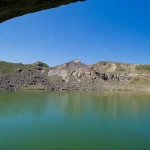 Lac cu apă verde-smarald în Munții Măcinului, loc de poveste pentru weekend