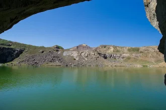 Lac cu apă verde-smarald în Munții Măcinului, loc de poveste pentru weekend